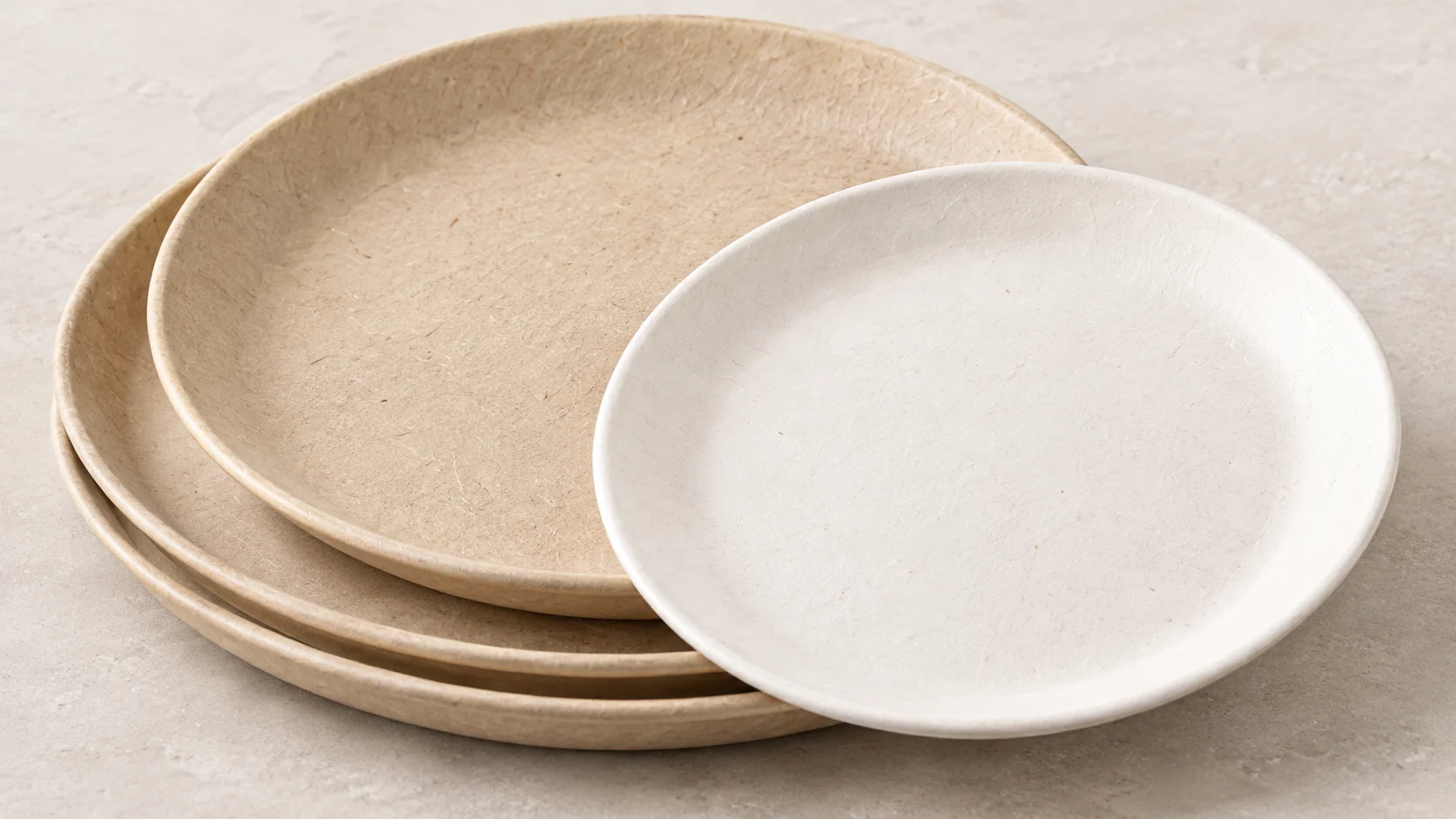 Stacked natural round plates with a white round plate